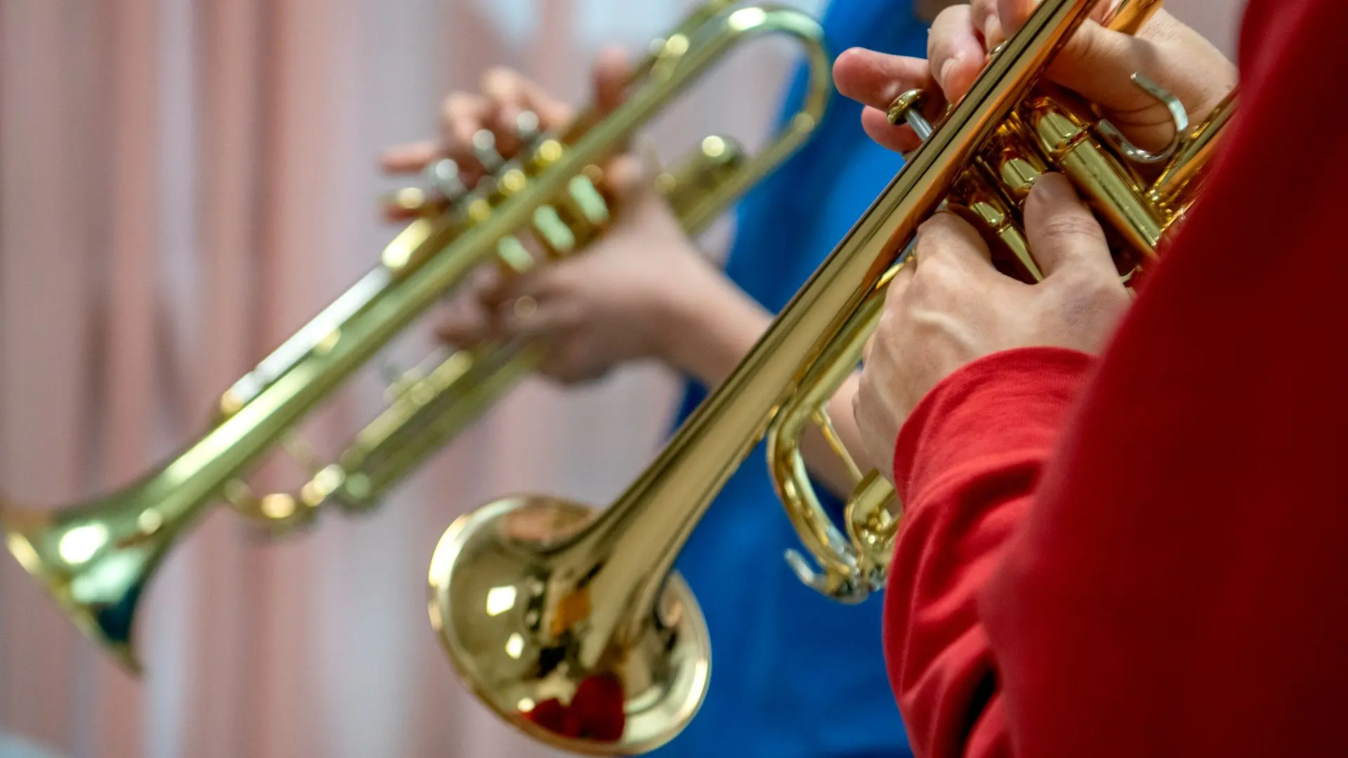 Foto på en elev och en lärare som spelar på varsin trumpet