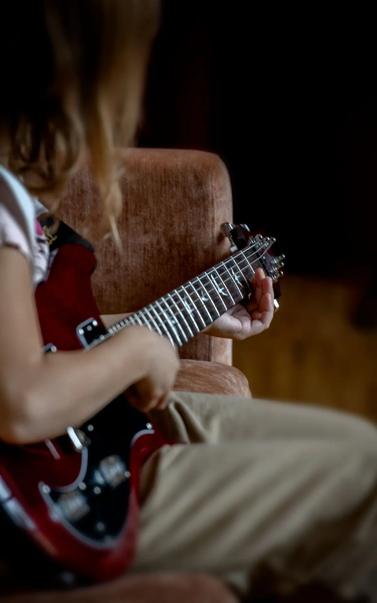 Foto på en elev som spelar på en röd elgitarr