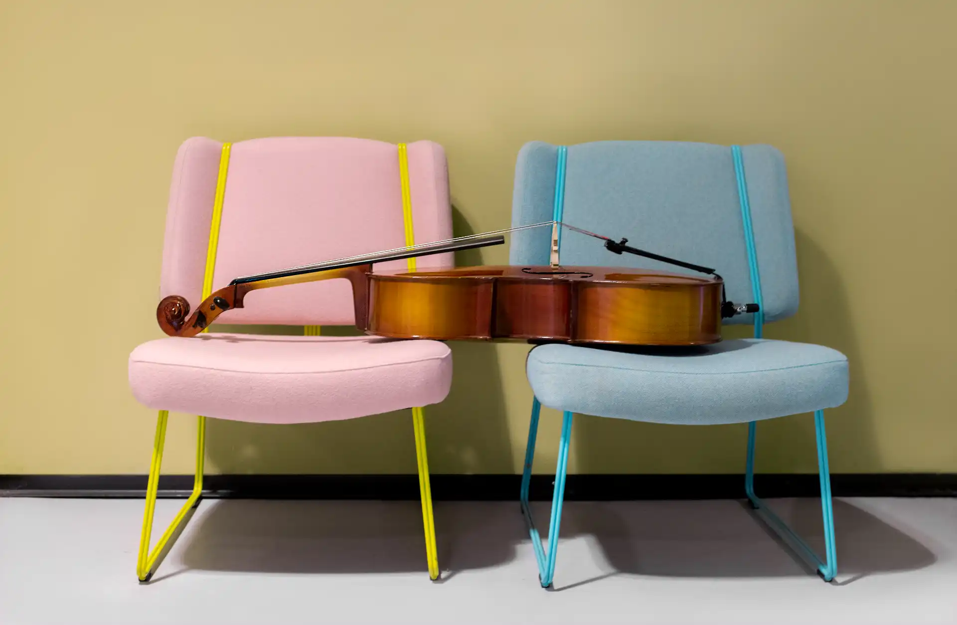 Bild på en cello som vilar på två fåtöljer